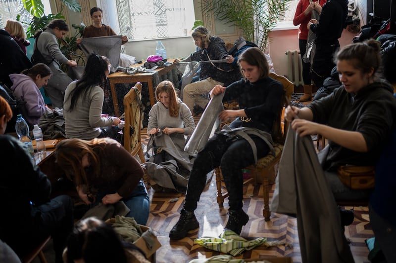 Ukrainian volunteers tear cloth into strips to make camouflage nets in Lviv, western Ukraine. AP