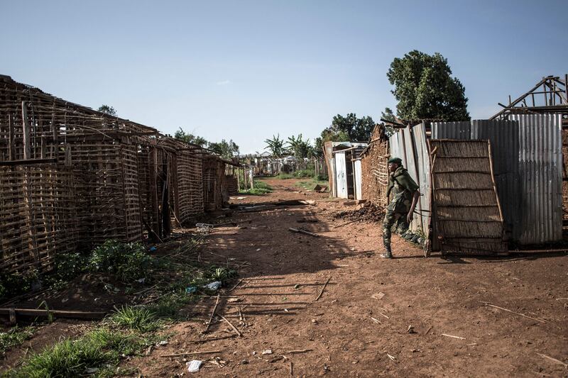 A member of the Armed Forces of the Democratic Republic of the Congo walks through a burned village on July 4, 2019, near Djugu. AFP