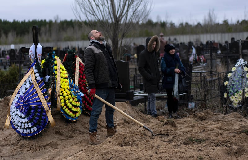 Cemetery worker Artem, exhausted, looks at the sky while working on the grave of Andriy Verbovyi, who was killed by Russian soldiers while serving in Bucha territorial defense. AP