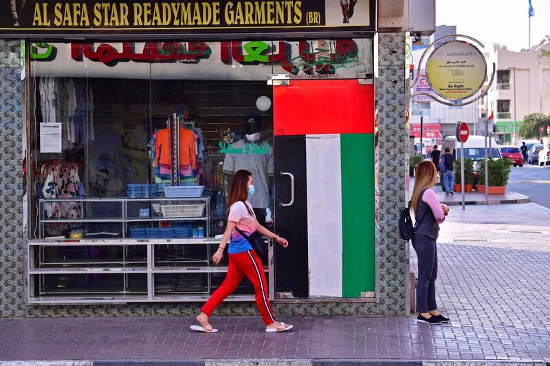 A woman walks by a closed shop in Dubai amid measures to curb the spread of coronavirus.  AFP