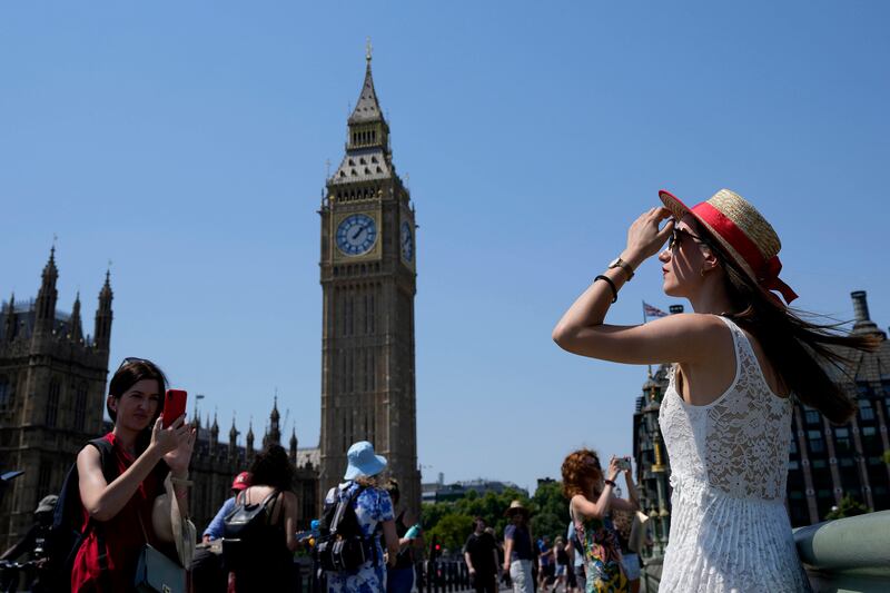 A tourist wears a hat to shield herself from the sun on Westminster Bridge in central London. AP