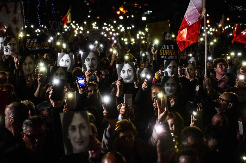 In this photo taken November 29, 2019, people holding placards and photos of journalist Daphne Caruana Galizia stage a protest called for by the journalist's family and civic movements outside the office of the prime minister in Valletta, Malta.