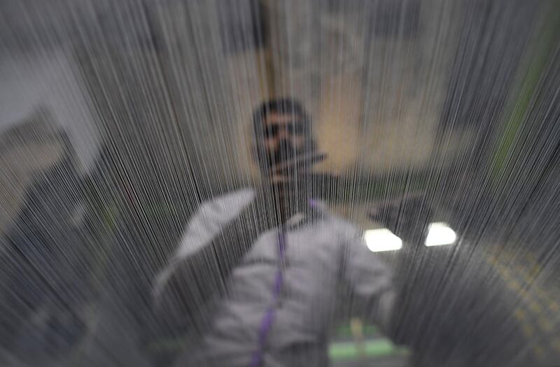 A Pakistan textile labourer checks the quality of the yarn at a power loom in Karachi. The financial capital and the largest industrial city of Pakistan  AFP