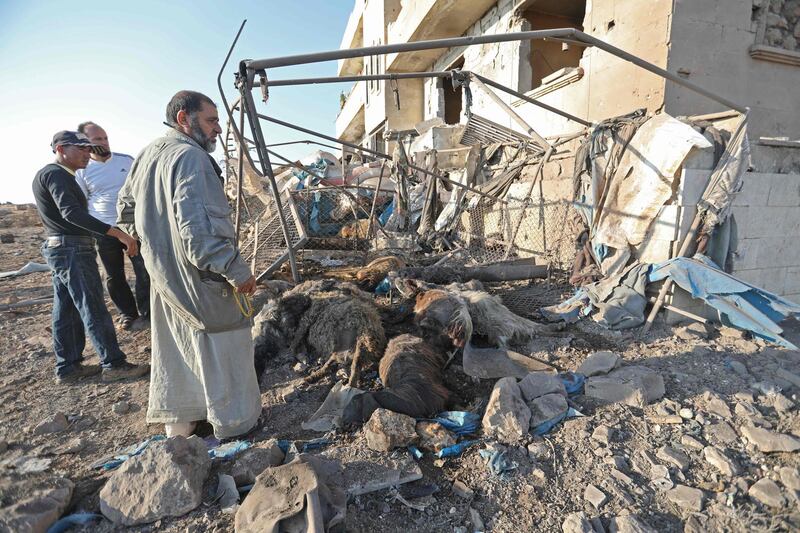 Syrian men look at a destroyed sheep pen following a reported Russian air strike in the village of al-Daher in Syria's northwestern Idlib province on September 11, 2019. Russia carried out air strikes on jihadist targets in northwestern Syria the previous day for the first time since it declared a truce on August 31, a war monitor said. / AFP / Omar HAJ KADOUR
