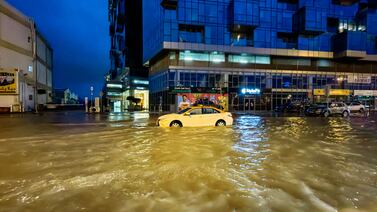 A taxi drives through a flooded street following heavy rains in Dubai. AFP
