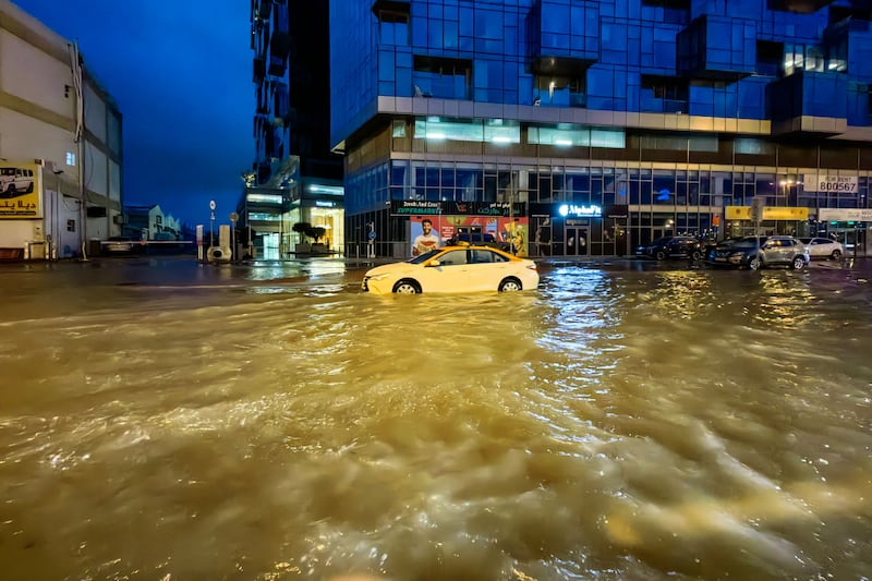 A taxi drives through a flooded street following heavy rains in Dubai. AFP