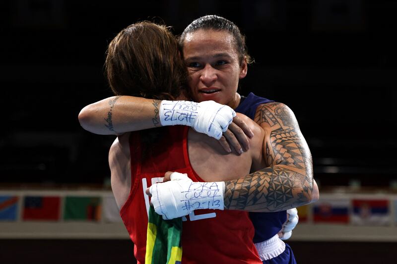 Ireland's Kellie Anne Harrington (red) and Brazil's Beatriz Ferreira hug after their women's light (57-60kg) boxing final bout during the Tokyo 2020 Olympic Games at the Kokugikan Arena in Toky.