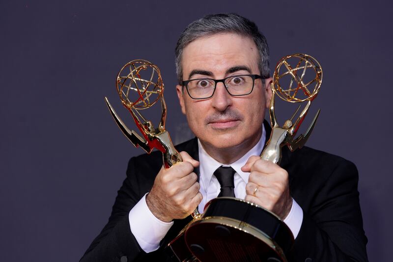 John Oliver poses for a photo with the awards for Outstanding Writing for a Variety Series and Outstanding Variety Talk Series for 'Last Week Tonight with John Oliver'.  AP