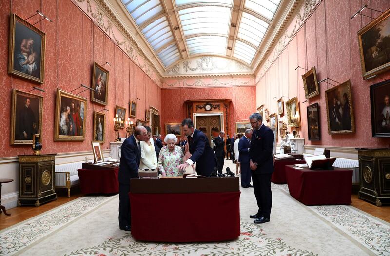 King Felipe VI (2R) and Queen Letizia (2L) look at a display of Spanish items from the Royal Collection with Britain's Queen Elizabeth II (C) and Prince Philip, Duke of Edinburgh (L) at Buckingham Palace in central London on July 12, 2017. Neil Hall.