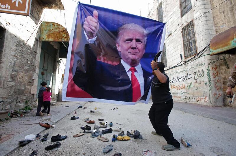 A Palestinian demonstrator throws a shoe at a poster of US president Donald Trump during a protest against his support of Israel. The protesters were also demanding that the Israeli army re-open Shuhada Street near a Jewish settler enclave in the heart of the flashpoint West Bank city of Hebron. Hazem Bader / AFP / February 24, 2017