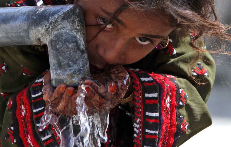 A girl drinks water from a community tap in Pakistan's Balochistan province after a 7.7 magnitude quake struck in September 2013, killing more than 820 people and injuring hundreds