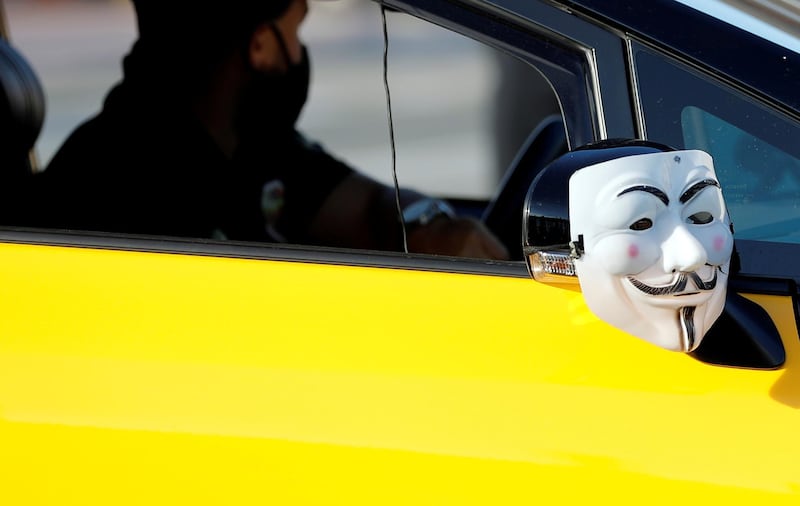 A Guy Fawkes mask hangs on a wing mirror as taxi drivers protest in Barcelona, Spain. Reuters