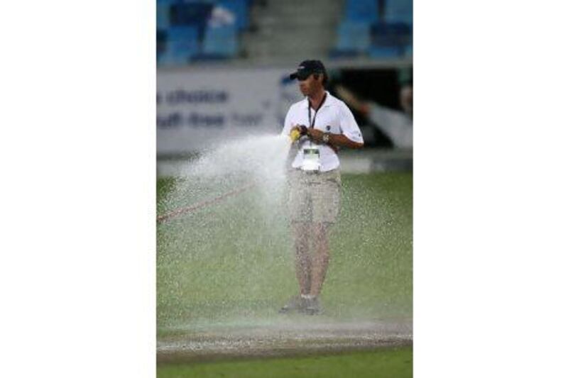DUBAI, UNITED ARAB EMIRATES - Nov 12 : Ground staff watering the pitch after the first Twenty20 cricket match of Cool & Cool Cup between Pakistan vs New Zealand at Dubai International Cricket Stadium in Dubai Sports City in Dubai. (Pawan Singh / The National) For Sports. *** Local Caption *** PS1211- CRICKETSTOCK050.jpg