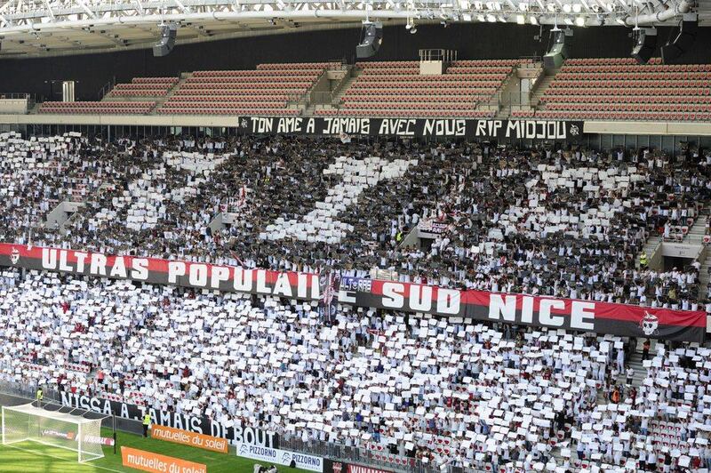 People stand in the grandstands as they hold white placards in tribute to the victims of the Bastille day attack in Nice before the French Ligue 1 football match between OGC Nice and Rennes on August 14, 2016, at the Allianz Riviera stadium in Nice, southern France. Franck Pennant / AFP