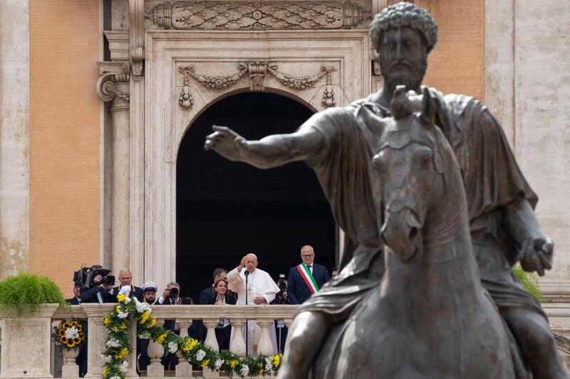 Pope Francis with Rome's Mayor Roberto Gualtieri, blesses a crowd in front of a bronze statue of Roman Emperor Marcus Aurelius at Rome's Piazza del Campidoglio (Capitol Hill). AP