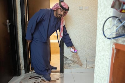 AJMAN, UNITED ARAB EMIRATES. 16 MAY 2019. Four years after they moved in, residents and apartment owners at Paradise Lake Towers are still waiting for their internet connection to be installed. The buildings are still also not connected to the electrical grid and several apartments face severe construction quality issues. Apartment owner Khaled Salem in his apartment where he shows off water damage from water that is seeping out of the wall and pushing paint and wallpeper off the walls. (Photo: Antonie Robertson/The National) Journalist: Ruba Haza. Section: National.