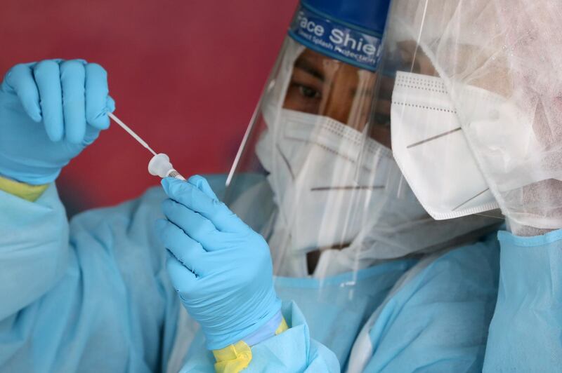 Medical worker holds a swab sample at a testing station in Klang, Malaysia. Reuters