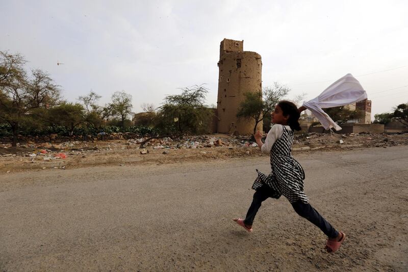 epa07738627 A Yemeni girl attempts to catch desert locusts flying over a neighborhood in Sana'a, Yemen, 24 July 2019. Swarms of desert locusts are spreading throughout several Yemen cities, including Sana'a. Traditionally, many Yemenis roast locusts and eat them.  EPA/YAHYA ARHAB