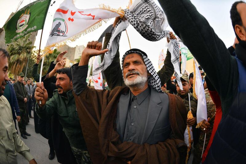 Iraqi mourners wave flags as the coffins of slain Iraqi paramilitary chief Abu Mahdi al-Muhandis, Iranian military commander Qasem Soleimani and eight others towards the Imam Ali Shrine in the shrine city of Najaf in central Iraq during a funeral procession on January 4, 2020. Thousands of Iraqis chanted "Death to America" today as they mourned the deaths of  al-Muhandis and Soleimani, who were killed in a US drone attack that sparked fears of a regional proxy war between Washington and Tehran. / AFP / Haidar HAMDANI
