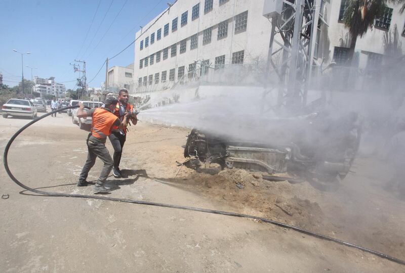 Volunteers use a hose during the clean-up as part of the Han'amerha (we will rebuild it) campaign.