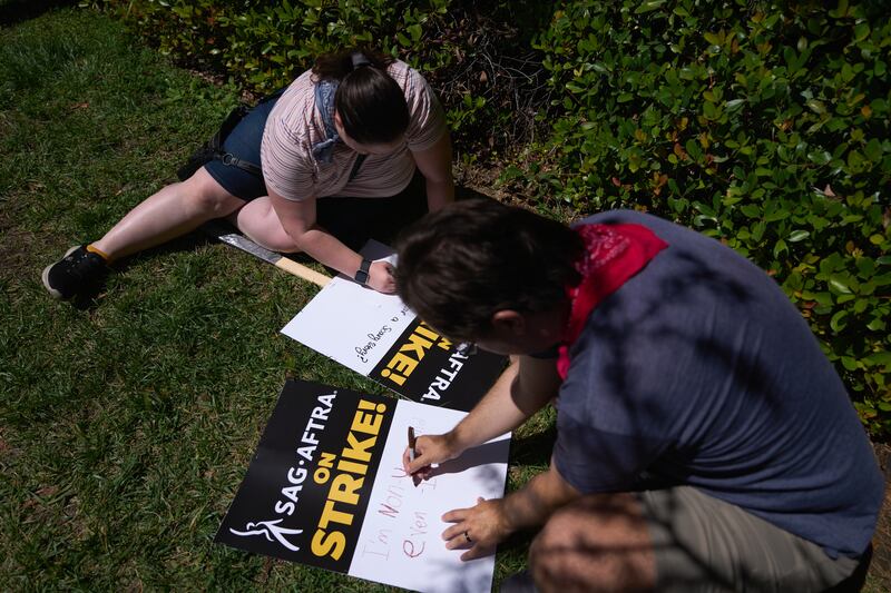 Sag-Aftra members create signs at a demonstration in front of Warner Bros studios. EPA