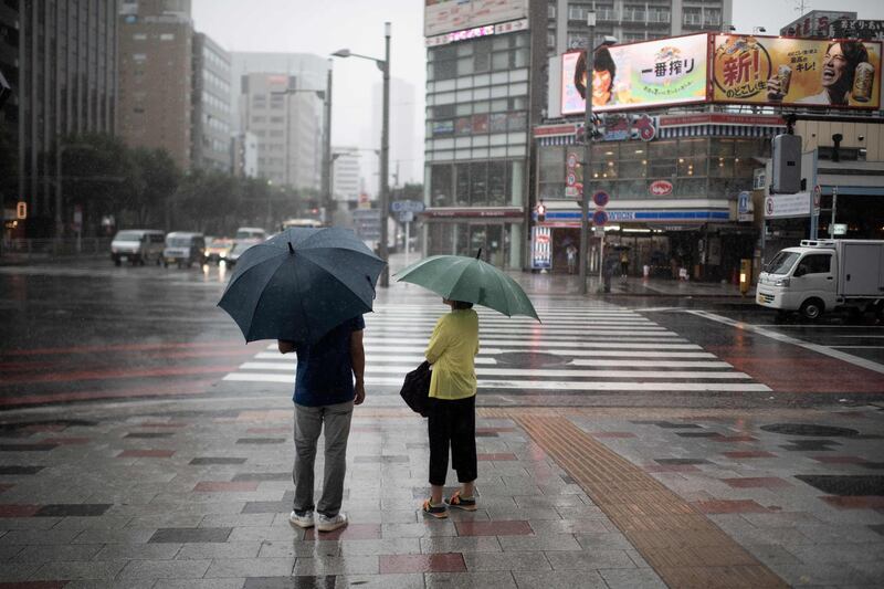 People protect themselves from the rain with an umbrella in Tokyo.  AFP / Martin BUREAU