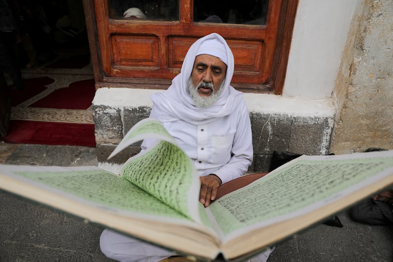 A worshipper reads the Quran at Sanaa's Grand Mosque. Reuters