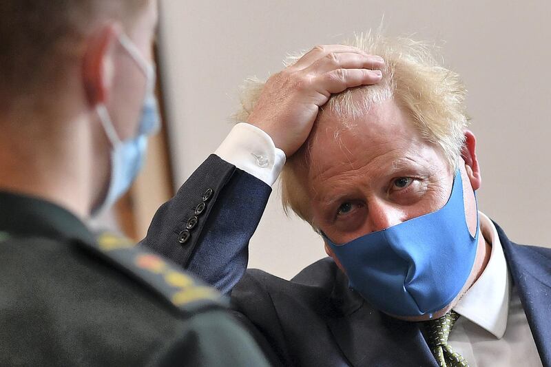 LONDON, UNITED KINGDOM - JULY 13: Britain's Prime Minister Boris Johnson (R), wearing a face mask or covering due to the COVID-19 pandemic, talks with a paramedic as he visits the headquarters of the London Ambulance Service NHS Trust  on July 13, 2020 in London, England.  (Photo by Ben Stansall-WPA Pool/Getty Images)