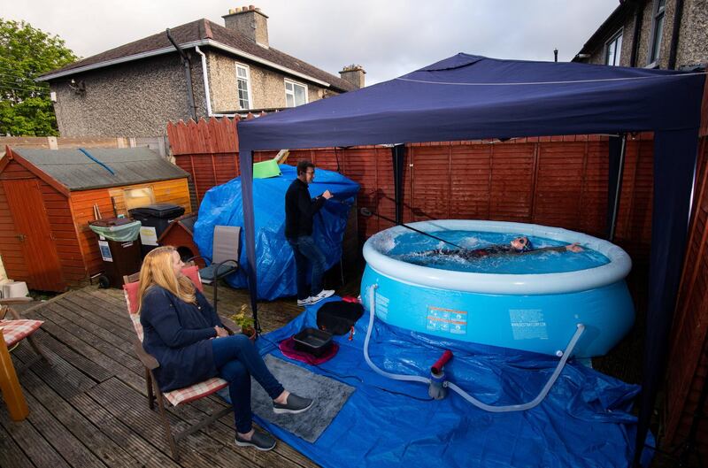 Dublin , Ireland - 29 April 2020; Swimmer Mia Whelan-O'Connor of ESB Swimming Club swims in her back garden in an inflatable pool, in Inchicore, Dublin, using a swimming parachute and a bungee cord with the assistance of her Dad Michael and Mother Carol. (Photo By Ramsey Cardy/Sportsfile via Getty Images)