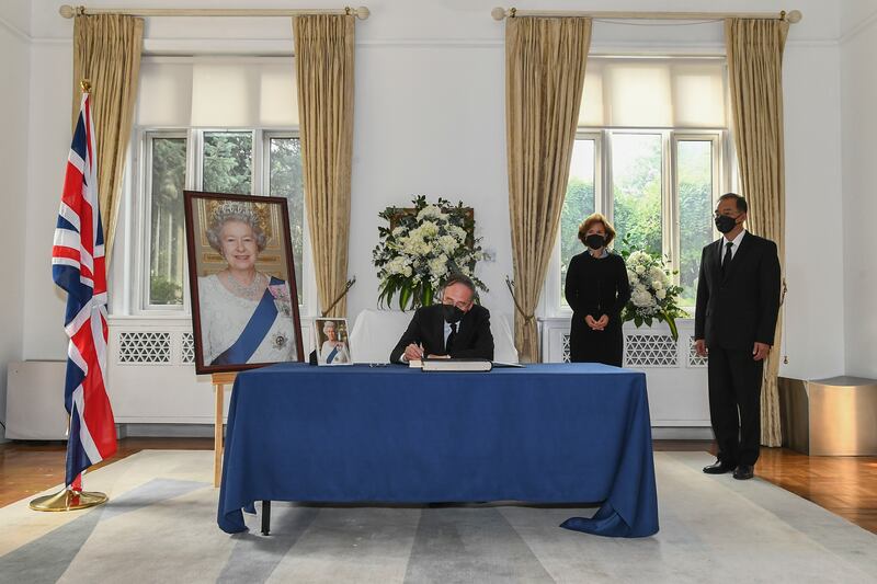Chinese Vice President Wang Qishan signs a condolence book at the British Embassy in Beijing to mourn the passing of Queen Elizabeth II. Xinhua via AP