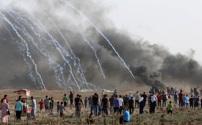 Protesters walk toward the fence where the Israeli troops fire teargas while others burn tires near the fence of the Gaza Strip border with Israel, during a protest east of Gaza City. AP Photo