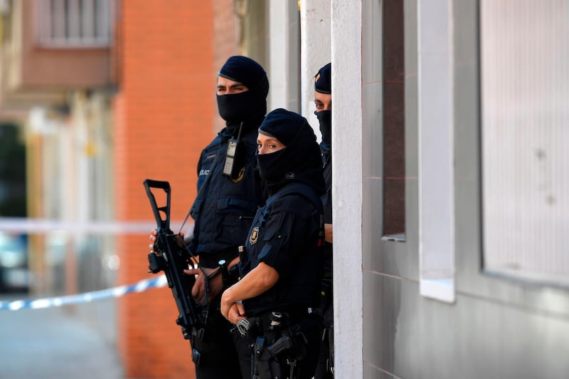 Catalan regional police (Mossos d'Esquadra) forces stand guard outside the apartment building of a man who tried to attack a police station in Cornella near the northeastern Spanish city of Barcelona on August 20, 2018. - A man armed with a knife was killed when he attacked a police station near Barcelona, police said. (Photo by LLUIS GENE / AFP)