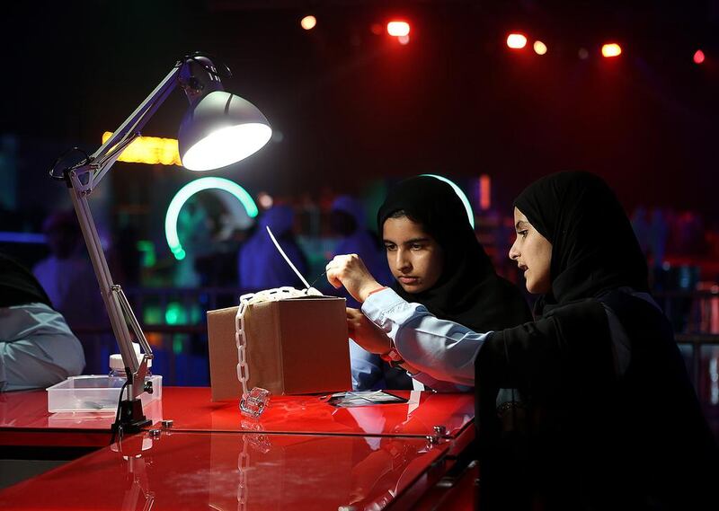 Rouda Yousef, left, and El Yazi Ismaeil of Al Maha School take part in the ‘tamper evident’ during the Cyber Quest event and contest at Adnec in Abu Dhabi. Satish Kumar / The National