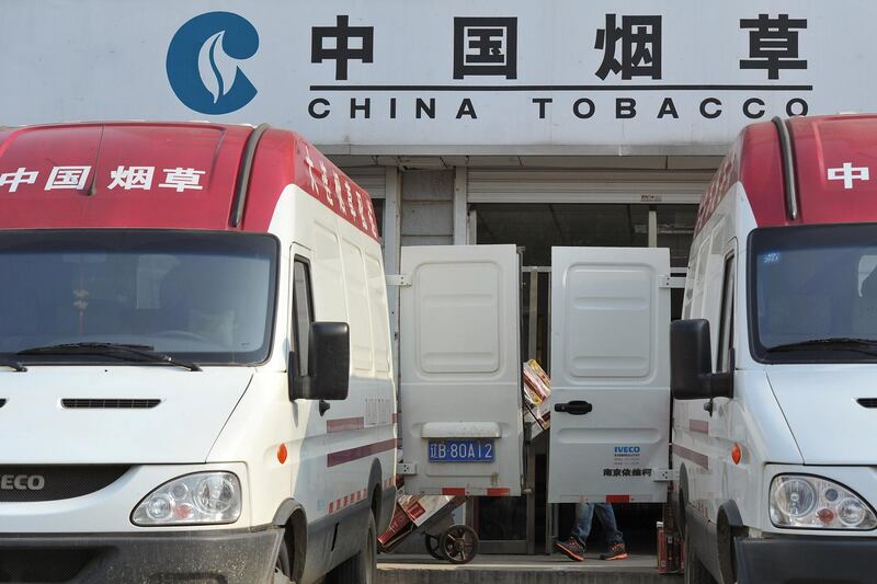 A worker transports cigarettes to vehicles outside a China Tobacco wholesale centre in Dalian, Liaoning province, China May 11, 2012. Picture taken May 11, 2012. REUTERS/Stringer  ATTENTION EDITORS - THIS IMAGE WAS PROVIDED BY A THIRD PARTY. CHINA OUT.
