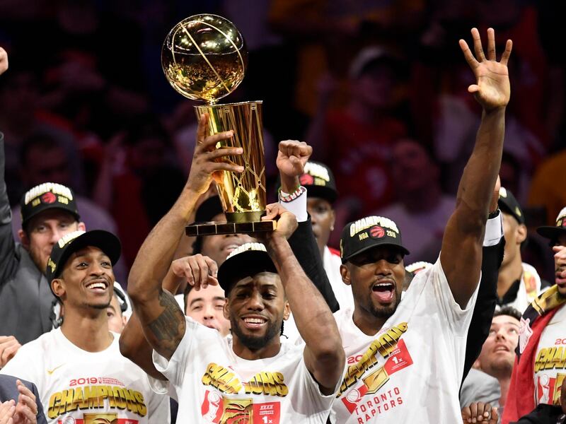 Toronto Raptors forward Kawhi Leonard, centre, holds the Larry O'Brien NBA Championship Trophy after the Raptors defeated the Golden State Warriors 114-110 in Game 6 of the NBA Finals, in Oakland, California. AP Photo