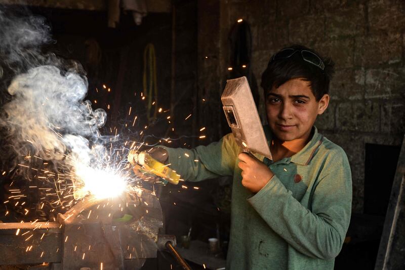 A young Syrian boy works at a car repair shop in the town of Jandaris, in the countryside of the north-western city of Afrin in the rebel-held part of Aleppo province, a day before the annual World Day Against Child Labour.