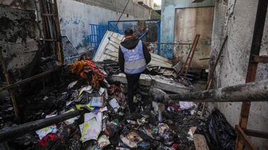 An UN employee checks a burnt area at a school housing displaced Palestinians in Nuseirat refugee camp. AFP