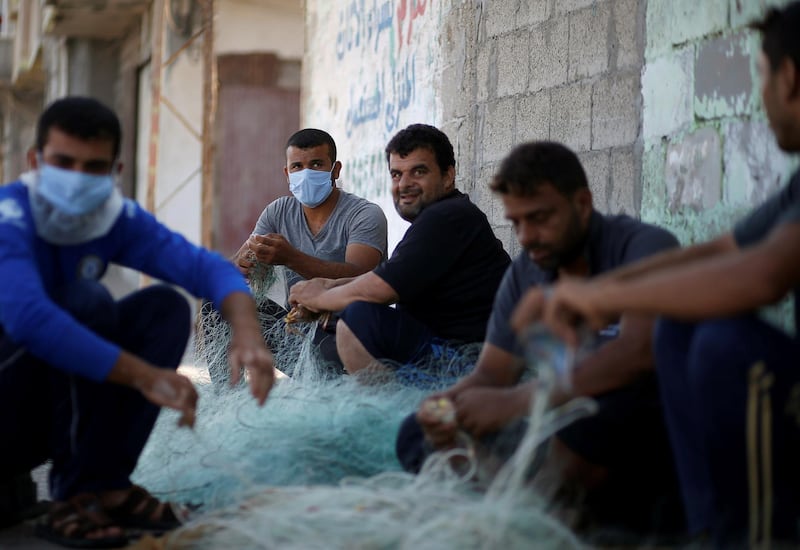 Palestinian fishermen remove crabs from a net in Gaza City. Reuters