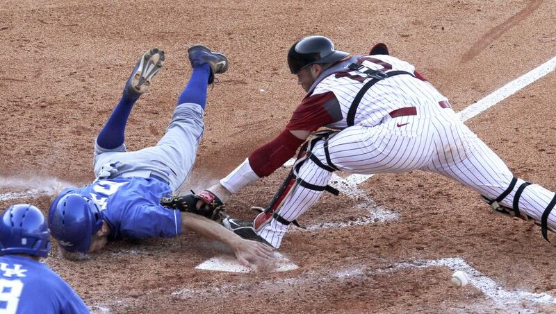 Kentucky’s Matt Reida slides into home and scores as the ball gets away from Alabama’s Wade Wass (10) during the fourth inning of a Southeastern Conference NCAA college baseball tournament game in Hoover, Ala. Butch Dill / AP