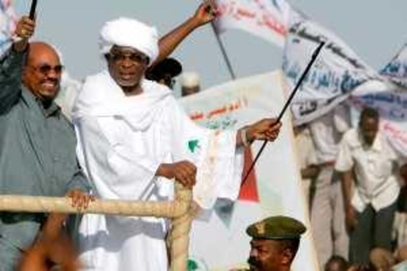 Sudanese President Omar al-Beshir (L) waves his trademark cane as he rides at the back of vehicle with governor Yussef Kaber (R) during a rally in El-Fasher, the capital of North Darfur state, on February 24, 2010. "The war in Darfur is over," Beshir said in a speech in the war-torn region, adding that 57 members of a key rebel group, 50 on death row, had been freed. AFP PHOTO/ASHRAF SHAZLY