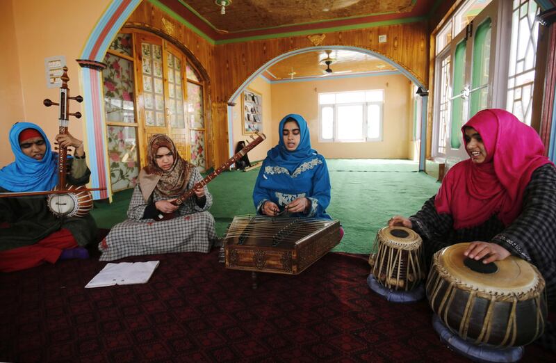 Kashmiri Muslim girls play instruments and sing Sufi music under the tutelage of music teacher, Muhammad Yaqoob Sheikh, on the outskirts of Srinagar. AFP

