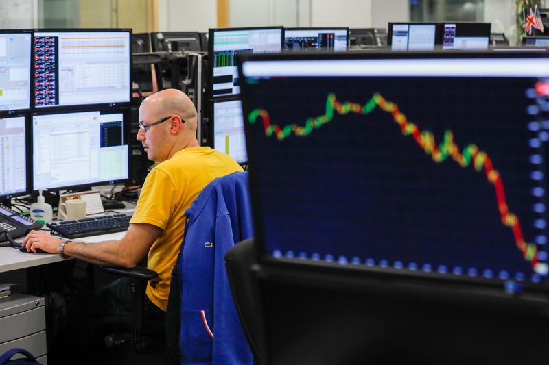 A screen shows the trajectory of the pound over this afternoon ahead of the U.K. parliament Brexit Deal vote as a trader monitors financial data on computer screens on the trading floor at ETX Capital, a broker of contracts-for-difference, in London, U.K., on Tuesday, Jan. 15, 2019. U.K. Prime Minister Theresa May is set to see her Brexit deal rejected in the biggest Parliamentary defeat for a British government in 95 years after her last minute pleas for support appeared to fall on deaf ears. Photographer: Luke MacGregor/Bloomberg