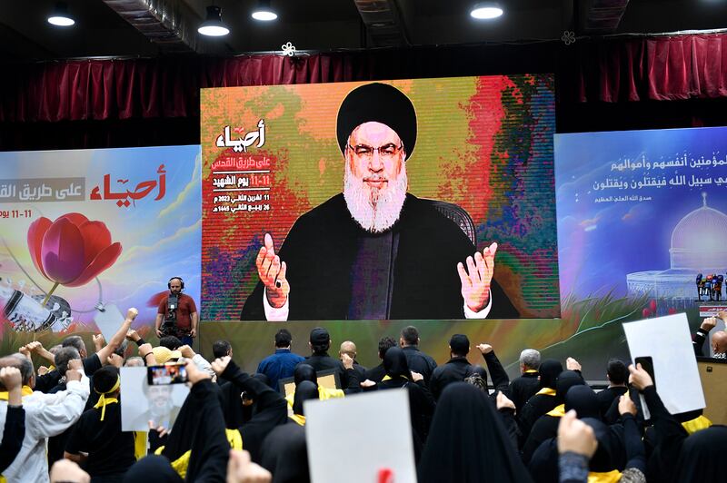Hezbollah supporters raise their hands as they listen to a speech by Hezbollah leader Hassan Nasrallah. EPA