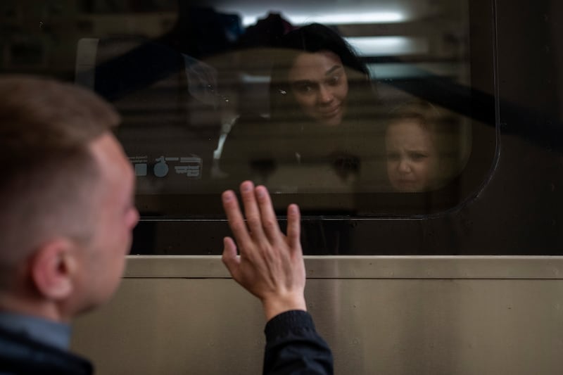 Ukrainian Nicolai, 41, says goodbye to his daughter Elina, 4, and his wife Lolita, on a train bound for Poland fleeing from the war at the train station in Lviv, western Ukraine. AP Photo