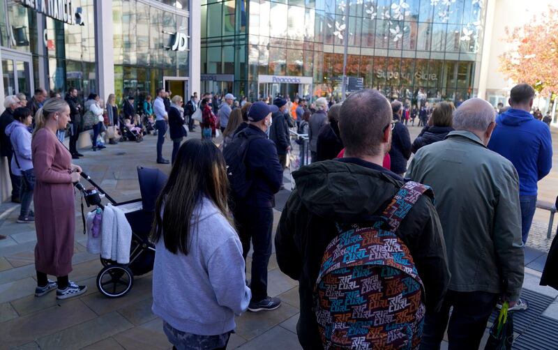 People observe a two-minute silence by the war memorial in Woking town centre, Surrey. PA
