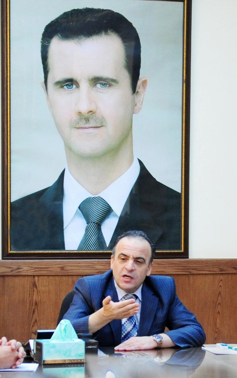 A picture taken on July 11, 2013 shows former electricity minister and newly-appointed Prime Minister Imad Khamis chairing a meeting at his office in the Syrian capital Damascus, as a giant portrait of Syrian President Bashar al-Assad is hung on the wall. - Syrian President Bashar al-Assad named Imad Khamis as the new prime minister of the war-ravaged country on June 22, 2016 and tasked him with forming a new government, the official news agency SANA reported. (Photo by STR / AFP)