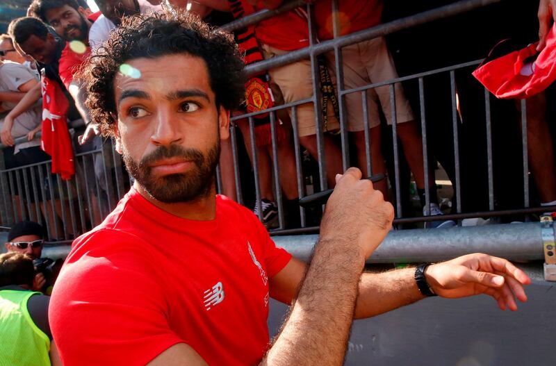 Mohamed Salah signs autographs after their game against Manchester United during their 2018 International Champions Cup match at Michigan Stadium in Ann Arbor, Michigan on July 28, 2018.  Liverpool FC beat Manchester United 4-1 in their friendly. / AFP / JEFF KOWALSKY
