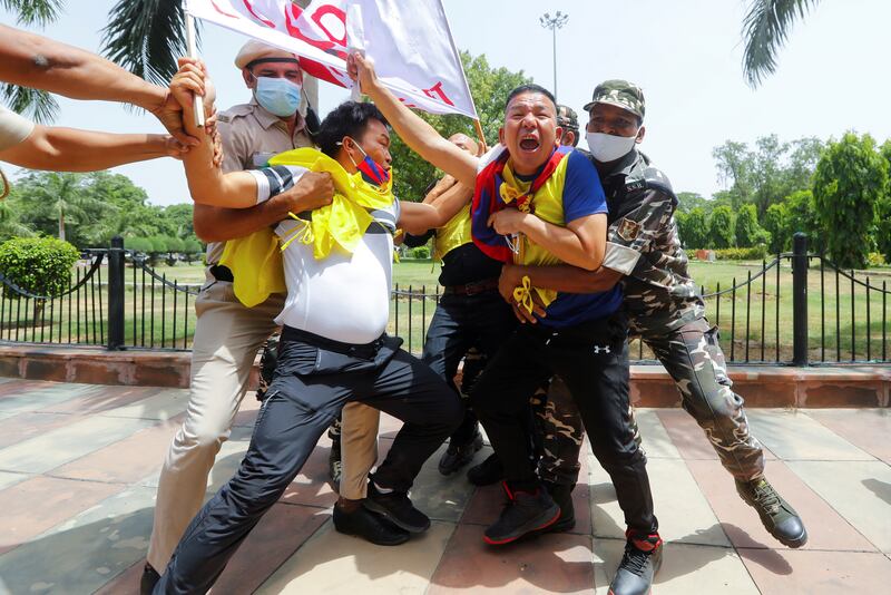Police officers detain Tibetan demonstrators during a protest against the Chinese Communist Party's 100-year anniversary celebrations, outside the Chinese embassy in New Delhi, India.