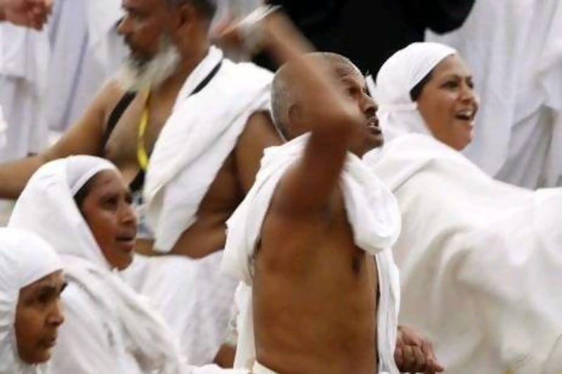 Muslim pilgrims cast seven stones at a pillar that symbolizes Satan during the annual haj pilgrimage, as part of a haj pilgrimage rite, on the first day of Eid al-Adha in Mina, near the holy city of Mecca.