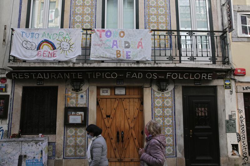 Banners in Italian and Spanish hang from balconies above a closed fado restaurant in Lisbon's Bairro Alto neighborhood. AP
